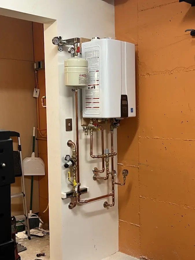Plumbing technician inspecting water heater connections in Saddlebrooke